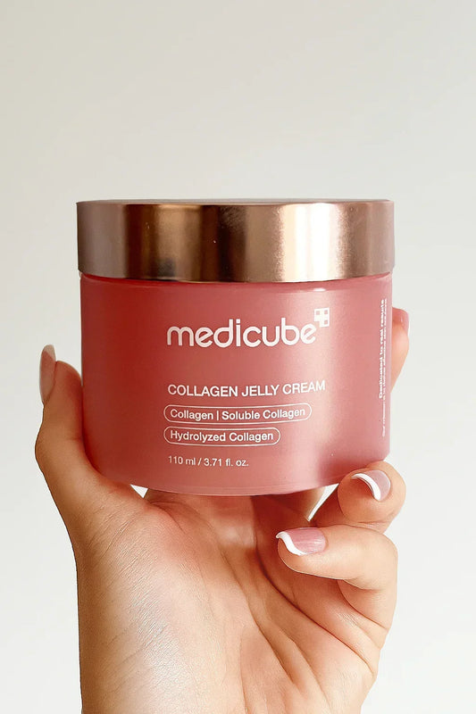 Hand holding a jar of Medicube Collagen Jelly Cream against a plain background
